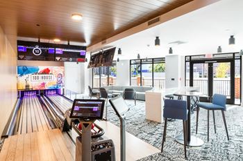 A bowling alley in a bowling club with tables and chairs